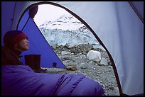 Camper lying in sleeping bag looks at Lamplugh Glacier. Glacier Bay National Park, Alaska ( color)