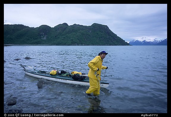 Kayaker towing kayak, East arm. Glacier Bay National Park, Alaska