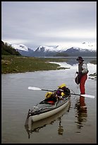 Kayaker standing in Scidmore Bay next to a shallow tidal channel. Glacier Bay National Park, Alaska ( color)