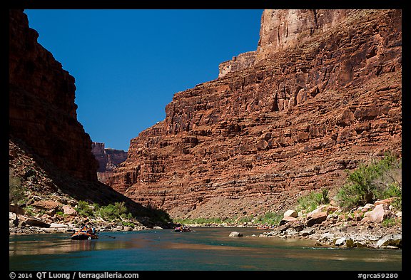 Rafts on Colorado River below towering cliffs. Grand Canyon National Park, Arizona