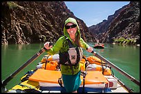 Woman standing on raft to paddle raft with oars. Grand Canyon National Park, Arizona