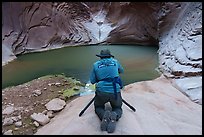 Photographer kneeling with tripod at a narrow slot canyon pool, North Canyon. Grand Canyon National Park, Arizona ( color)