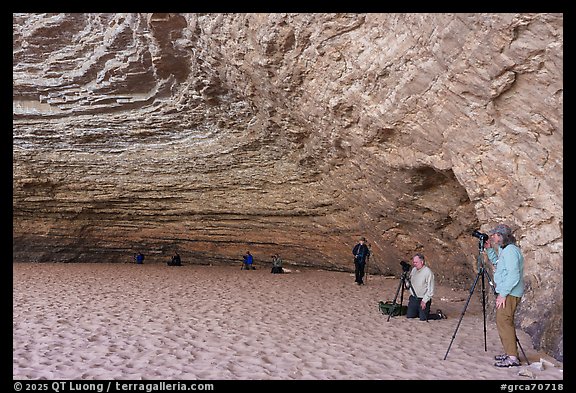 Group of photographers with tripods inside a large sandstone alcove, Red Cavern. Grand Canyon National Park, Arizona (color)