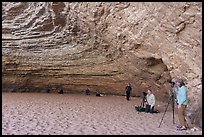 Group of photographers with tripods inside a large sandstone alcove, Red Cavern. Grand Canyon National Park, Arizona ( color)