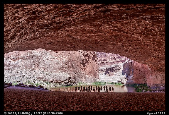 River trip participants silhouetted at the entrance of a Grand Canyon alcove overlooking the Colorado River, Red Cavern. Grand Canyon National Park, Arizona (color)