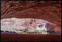 River trip participants silhouetted at the entrance of a Grand Canyon alcove overlooking the Colorado River, Red Cavern. Grand Canyon National Park, Arizona ( color)