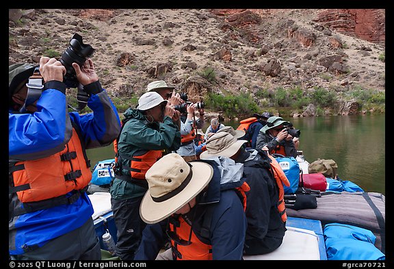 Photographers on a motorized raft wearing life jackets, taking pictures during a Grand Canyon river trip. Grand Canyon National Park, Arizona (color)