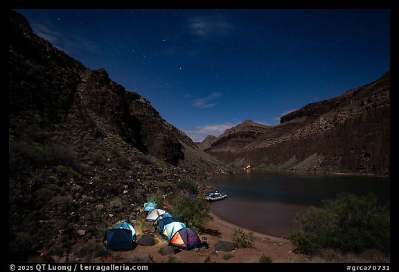 Illuminated tents at night in a remote Colorado River campsite surrounded by canyon cliffs in the Grand Canyon. Grand Canyon National Park, Arizona (color)