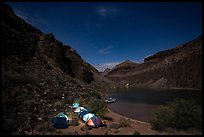 Illuminated tents at night in a remote Colorado River campsite surrounded by canyon cliffs in the Grand Canyon. Grand Canyon National Park, Arizona ( color)