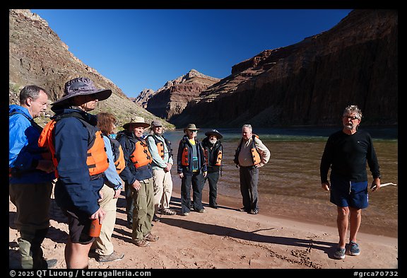 Group of rafters wearing life jackets gathered for a safety talk along the Colorado River on a Grand Canyon rafting trip. Grand Canyon National Park, Arizona (color)