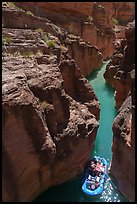 Raft navigating a tight passage through a red rock slot canyon of Havasu Creek with turquoise water. Grand Canyon National Park, Arizona ( color)