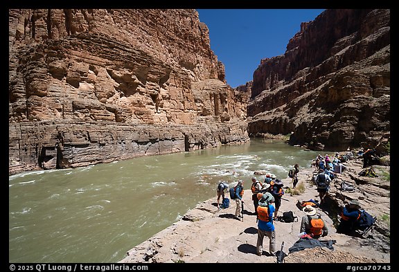 Large group of rafters in life jackets resting along the shoreline of the Colorado River. Grand Canyon National Park, Arizona (color)