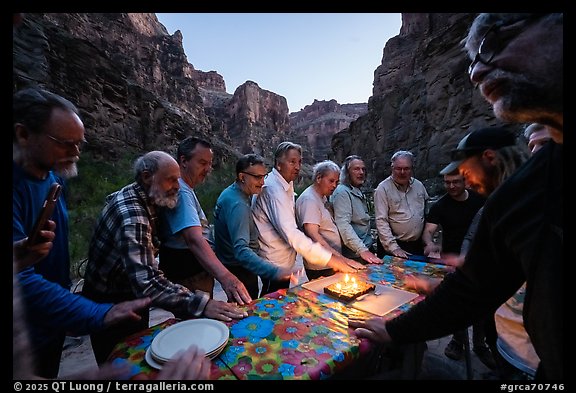 Rafters gathered around a birthday cake celebration at dusk. Grand Canyon National Park, Arizona (color)