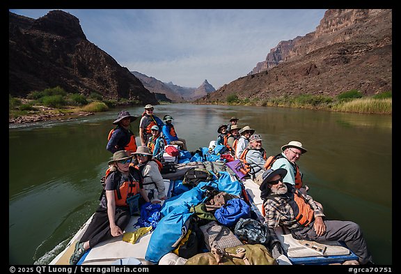 Rafters relax aboard a gear-packed motorized raft as it travels down the Colorado River during a Grand Canyon expedition. Grand Canyon National Park, Arizona (color)