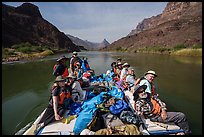 Rafters relax aboard a gear-packed motorized raft as it travels down the Colorado River during a Grand Canyon expedition. Grand Canyon National Park, Arizona ( color)