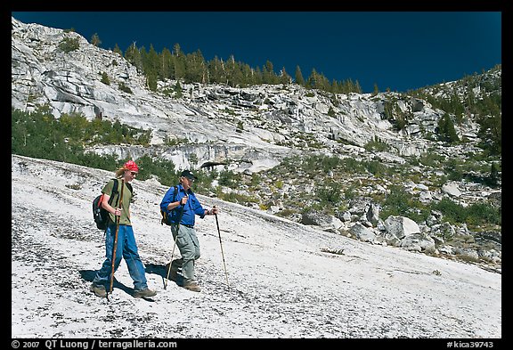 Father and son hiking on granite slab, Le Conte Canyon. Kings Canyon National Park, California