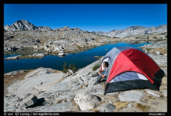 Man sitting in tent above lake, Dusy Basin. Kings Canyon National Park, California, USA.