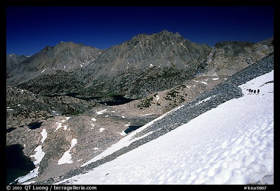 Snow field below Glen Pass with hikers in the distance, Kings Canyon National Park. California (color)