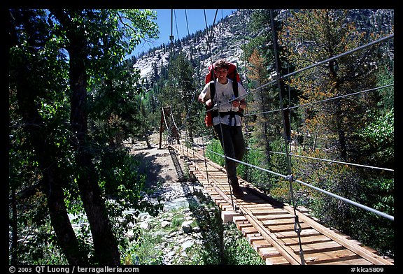 Hiker walking on Wood Creek suspension footbridge, Kings Canyon National Park. California