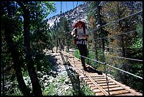 Hiker walking on Wood Creek suspension footbridge, Kings Canyon National Park. California
