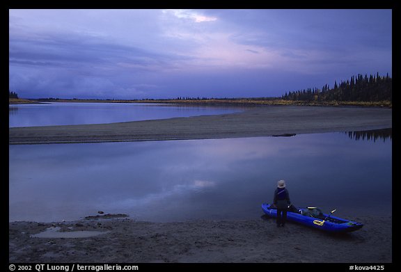 Standing next to the canoe on a sand bar, evening. Kobuk Valley National Park, Alaska (color)