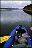 Canoeist reading a book while floating downriver. Kobuk Valley National Park, Alaska ( color)