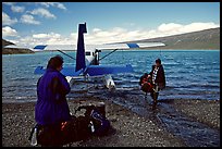 Pilot unloading a backpack from the floatplane on Lake Turquoise. Lake Clark National Park, Alaska ( color)