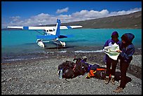 Backpackers dropped off by floatplane on Lake Turquoise orient themselves on the map. Lake Clark National Park, Alaska ( color)