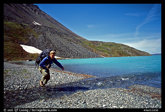 Jumping over a small stream next to Lake Turquoise. Lake Clark National Park, Alaska