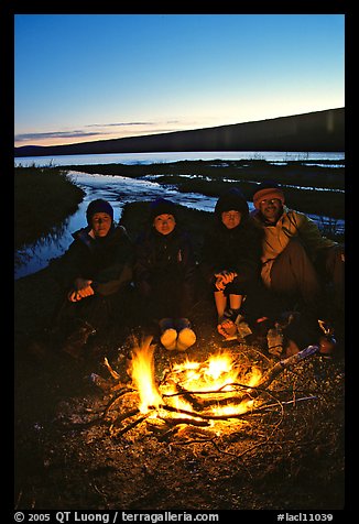 Campers warming toes in campfire next to Turquoise Lake. Lake Clark National Park, Alaska