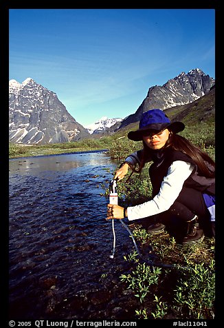 Woman filtering water from a stream. Lake Clark National Park, Alaska (color)