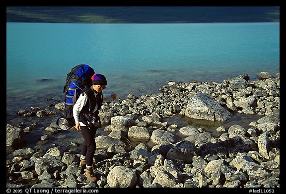 Backpacker walking on rocks on the shore of Turquoise Lake. Lake Clark National Park, Alaska