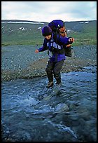 Backpacker crossing a stream on pebbles. Lake Clark National Park, Alaska ( color)