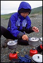 Backpacker cooks meal on gas campstove. Lake Clark National Park, Alaska ( color)