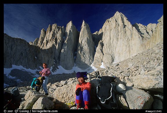 Man and woman pausing with backpacks below the East face of Mt Whitney. California (color)