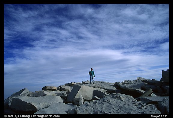 Hiker standing on flat rocks on top of Mt Whitney summit. Sequoia National Park, California
