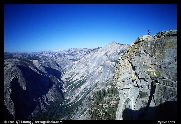 Hiker standing on top of Half-Dome, overlooking Tenaya Canyon. Yosemite National Park, California