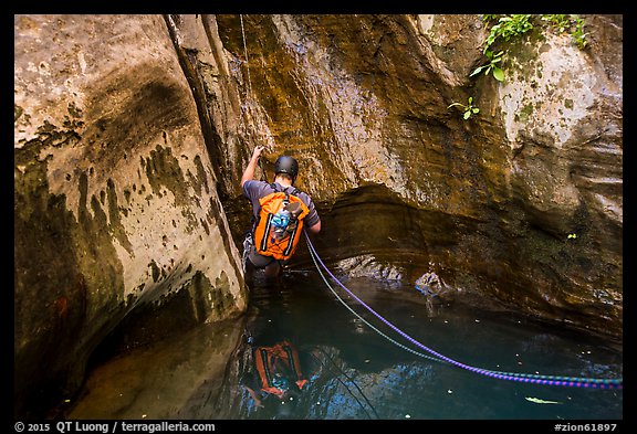 Canyoneer rappels into pool of water, Mystery Canyon. Zion National Park, Utah