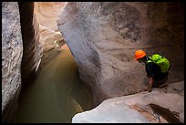 Canyoneer looks at water-filled pool. Zion National Park, Utah ( color)