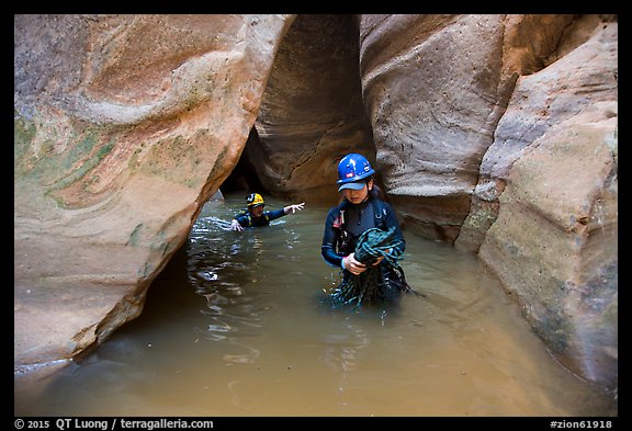 Woman carries rope, as man wades in chest-high water in Pine Creek Canyon. Zion National Park, Utah
