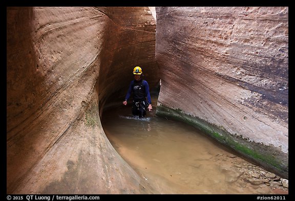 Hiker walks in water in Keyhole Canyon. Zion National Park, Utah