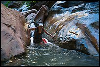 Woman walking in stream, Orderville Canyon. Zion National Park, Utah ( color)