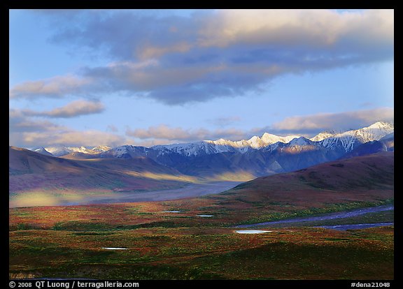 Tarn lakes, tundra, and snowy mountains of Alaska Range with patches of light. Denali National Park, Alaska, USA.