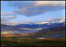 Tarn lakes, tundra, and snowy mountains of Alaska Range with patches of light. Denali National Park, Alaska, USA.