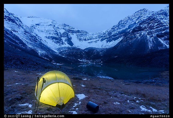 Lighted tent, lake, and Three River Mountain. Gates of the Arctic National Park, Alaska, USA.