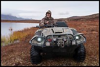 Nunamiut man driving all-terrain vehicle. Gates of the Arctic National Park ( color)