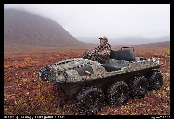Nunamiut man driving eight-wheeled all-terrain vehicle. Gates of the Arctic National Park, Alaska, USA.