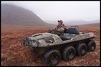Nunamiut man driving eight-wheeled all-terrain vehicle. Gates of the Arctic National Park ( color)