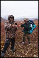 Nunamiut man and visiting backpacker with cell phones. Gates of the Arctic National Park ( color)