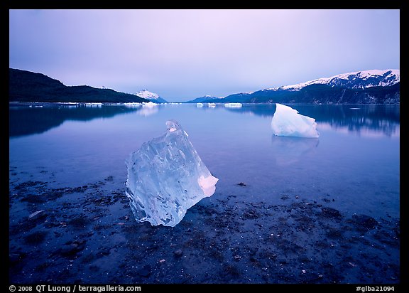 Beached translucent iceberg and Muir inlet at dawn. Glacier Bay National Park, Alaska, USA.